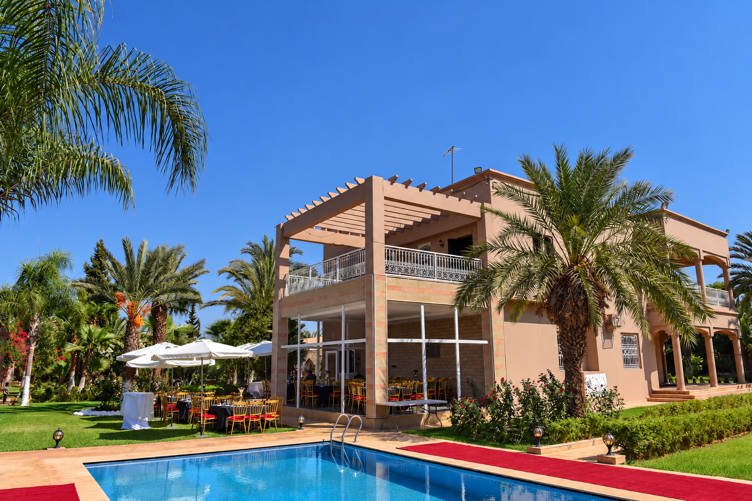 Garden, palms and residence facade in Marrakech.